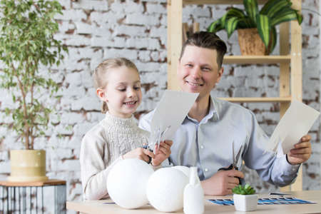 Dad and daughter create a model of planet Earth.の写真素材