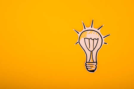 Paper drawn bulb on a yellow backgroundの写真素材