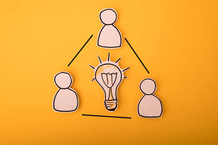 Business and design concept - paper humans with a bulbの写真素材