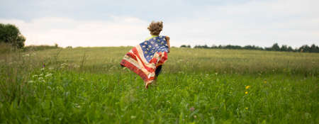 Patriotic holiday. Happy kid, cute little child girl with American flag.
