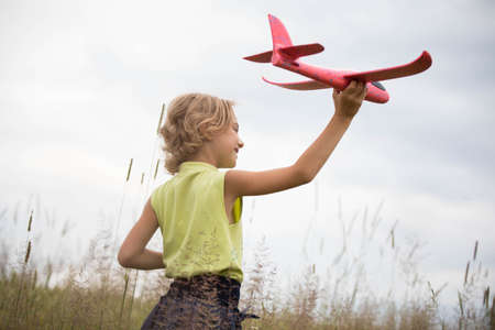 Happy kid playing with toy airplaneの写真素材