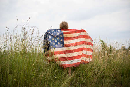 Patriotic holiday. Happy kid, cute little child girl with American flag.