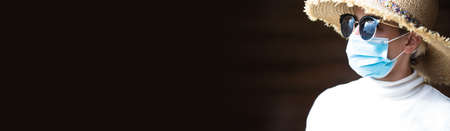 Studio portrait of young woman wearing a face mask, looking at camera.の写真素材