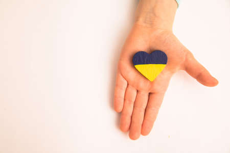 High angle view of child hands holding ukraine flag painted heartの写真素材