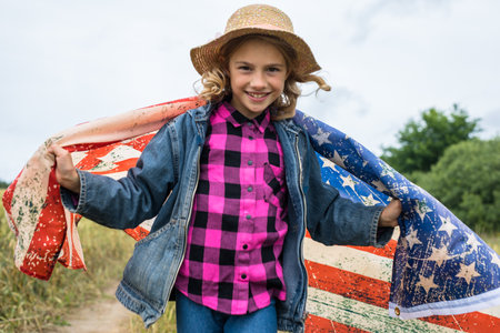 Little girl with american flag on the fieldの写真素材