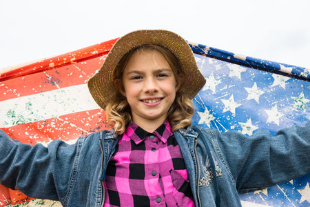 Little girl with american flag on the fieldの写真素材