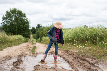 Girl run through the puddles and play.の写真素材