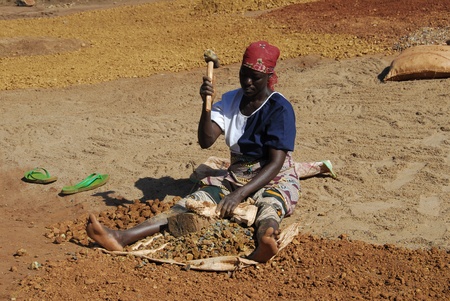 Shinyanga, Tanzania March 18, 2010: woman miner quarries stones. Prepare gravel quarries to be sold for a dollar a day. To them it was the only occupation to feed their familiesのeditorial素材