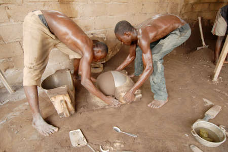 Ouagadougou, Burkina Faso - November 13, 2010:Workers in a small industry of pots in Ouagadougou.The tools and materials for the construction of the pots are very rudimentary waste industries, metal trash can, soft drink cans and old radiatorsのeditorial素材