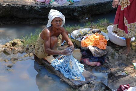Nosy Be, Madagascar-16 October,2006:An old woman washing clothes in a river. Many areas Nosy Be suffer from intense and prolonged drought. のeditorial素材