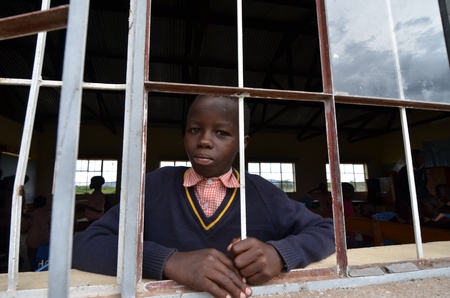 Masai Mara,Kenya,Africa,October 17, 2011. An African unidentified kid looking at the camera while studying in a small school in Masai Mara, in Masai Mara, Kenya のeditorial素材