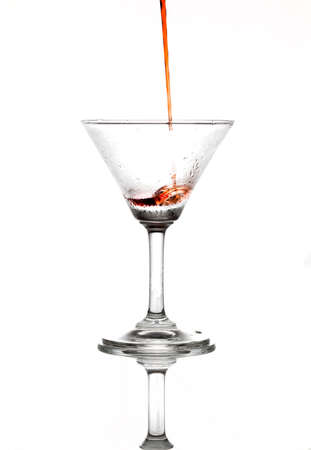 Pouring red wine in to champagne glass on isolate white backgroundの写真素材