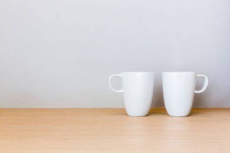 White cups on wooden bar table in bed room with blank space for textの写真素材