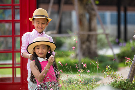 Little asian boy and girl enjoy playing on red sofa, Valentine or love conceptの写真素材