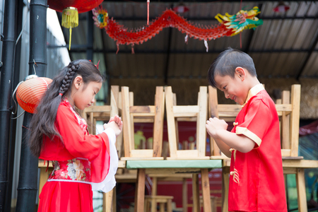 Young chinese boy and girl smiling and happy in lunar new year costume dressの写真素材