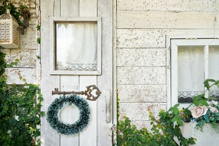 Christmas garland hanging on white wooden door, vintage backgroundの写真素材