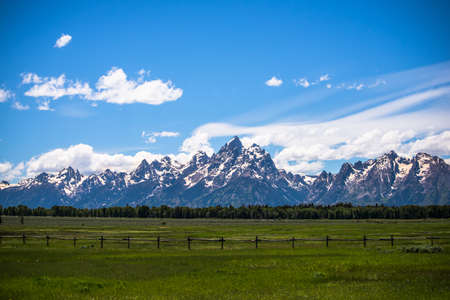 Grand Tetons behind a picket fence and fieldの写真素材