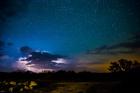Long exposure of the stars with a burst of lightning from a small thunderstormの写真素材