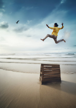 Men jumping in the air on the beach at sunset. Travel and vacation concept.の素材