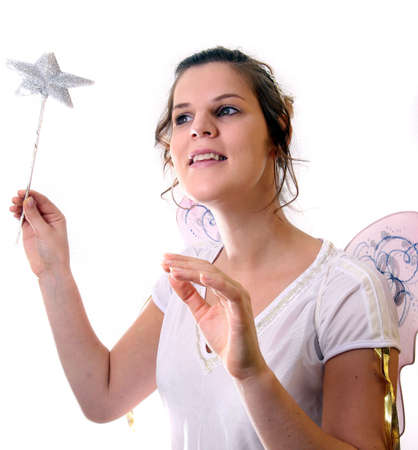 Happy Christmas Fairy - A young beautiful cute and happy Christmas fairy with wings and a magic wand getting ready for Christmas! Isolated over white!の写真素材