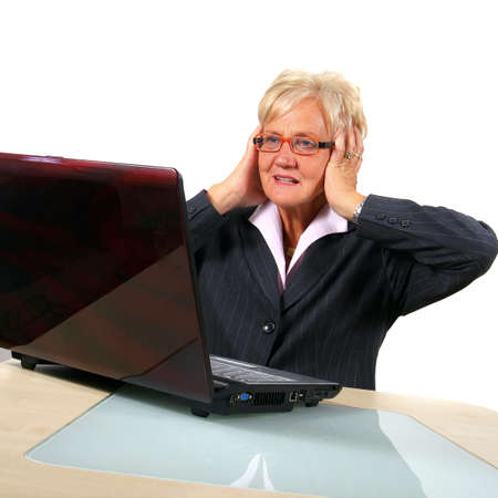 Shocked Senior Business Woman In Front Of Laptop - A businesswoman in her sixties in front of a...