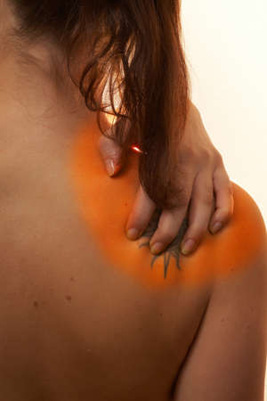 Back Problems - A young woman holds her back in pain! The area on the shoulder is higlighted to...