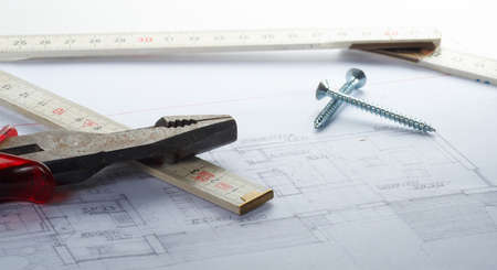 A house plan with srews pliers and a scale.