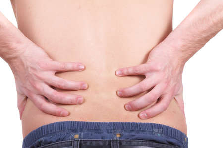 A young man holds back with both hands in pain. Isolated over white.