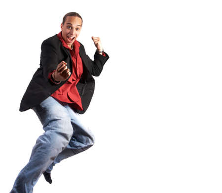 A young businessman with a red shirt, a jacket and blue jeans is jumping in joy. Isolated over white. Slight motion bluriness is intended.の写真素材