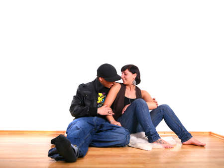 Young stylish couple sitting on the floor of their new home! Pure white wall leaves big copyspace.の写真素材