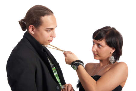 Young couple in love is about to kiss. The woman is pulling the man closer with his necklace. Isolated over white.の写真素材