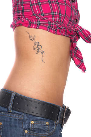 Portrait of a young woman wearing a pink shirt and blue jeans. She is showing off her beautiful tattoo. Isolated over white.の写真素材