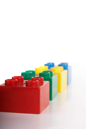 Building bricks in different colors over gradient background with lots of copyspace. The bricks have slight shadows to show the depth.の写真素材