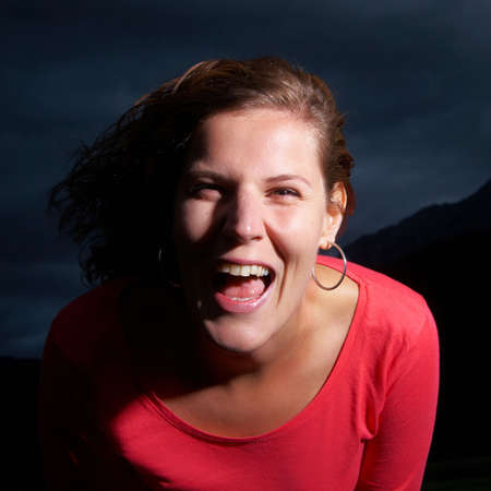 Young strong and confident woman under a dark sky before a thunderstorm.の写真素材
