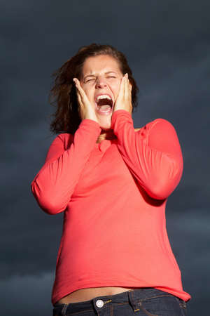 Young woman is in shock under a dark sky before a thunderstorm.