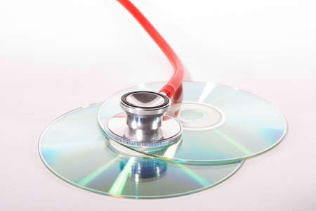 Stethoscope and a cd disk - checking the content of the disk. Could be used for medical and computer purposes!の写真素材
