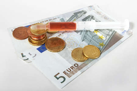 A syringe with money - symbolizing expensive healthcare systems.の写真素材