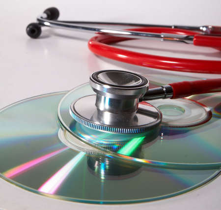 Stethoscope and a cd disk - checking the content of the disk. Could be used for medical and computer purposes!の写真素材