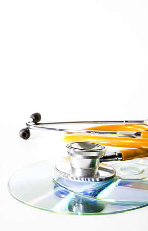 Yellow Stethoscope and a cd disk - checking the content of the disk. Could be used for medical and computer purposes! Highkey image!の写真素材