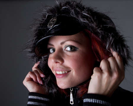 Young fashion model over dark background. She is wearing warm outfit. Very sexy.
