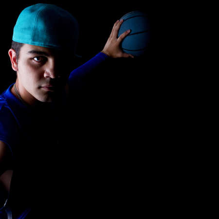Young teenage basketball player in a studio setting with hip athletic clothing.の写真素材