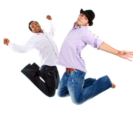 Young group of teenagers with trendy clothes jumping in joy over white background.の写真素材