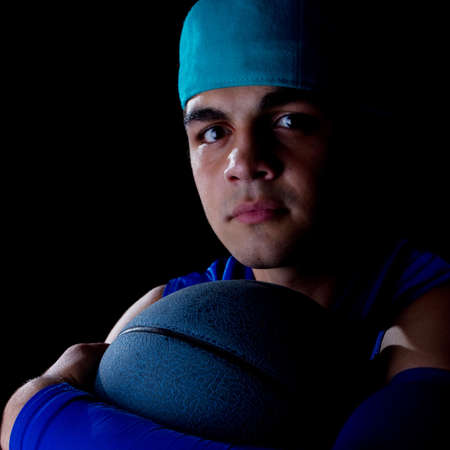 Young teenage basketball player in a studio setting with hip athletic clothing.の写真素材