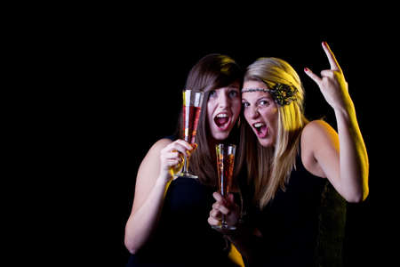Young fresh teenage girls partying with drinks. Isolated over black background.の写真素材