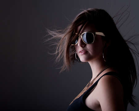 Young stylish teenage girl over black background with nice long hair.の写真素材