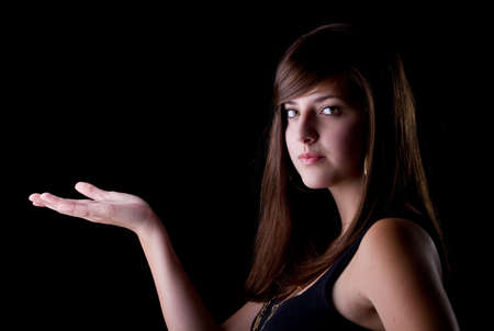 Teenage girl presenting with her hand. Isolated over one colored background.の写真素材