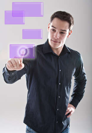 Young european male model is pushing a digital touchscreen buitton.の写真素材