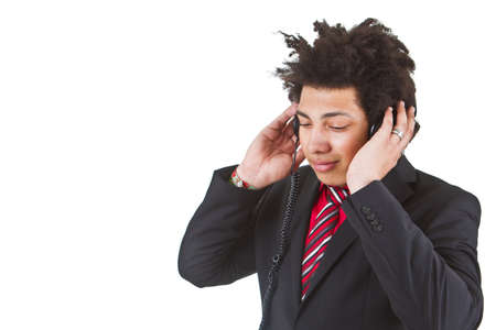 Young afro american business man with headphones listening to music. Isolated over white.の写真素材