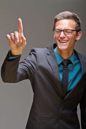 Young business man pushing digital buttons. Cool man with glasses.の写真素材