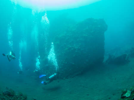 Group of scuba divers exploring the famous ship wreck USS Liberty at Tulamben on Bali Indonesiaの写真素材